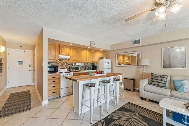 a kitchen with granite countertop a refrigerator and a stove top oven