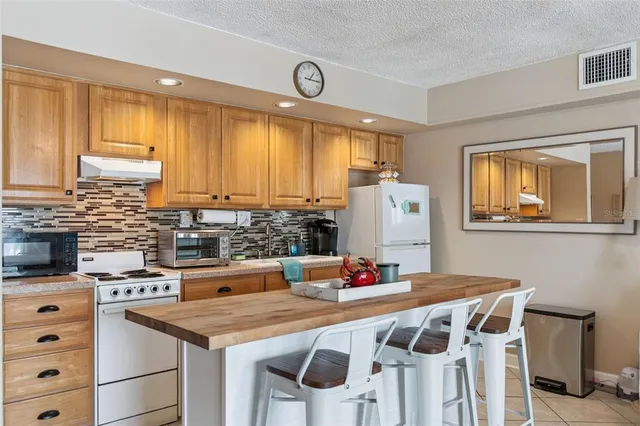 a open kitchen with stainless steel appliances granite countertop a stove a sink dishwasher and cabinets with wooden floor