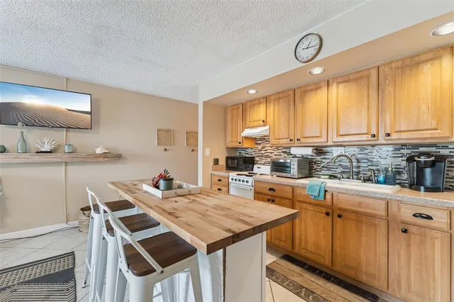 a living room with granite countertop furniture a fireplace and a chandelier