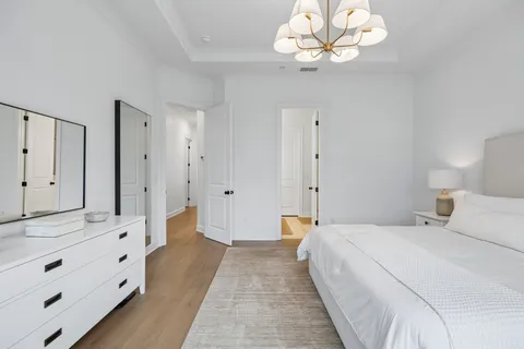a bedroom with a large bed and a chandelier