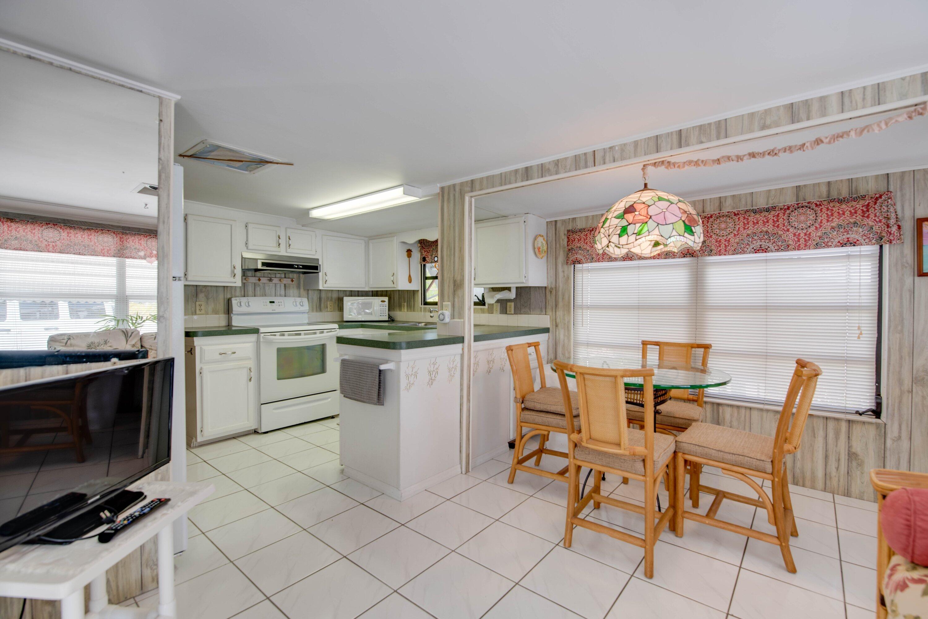 701 Spanish Main Drive, Unit 21 Cudjoe, FL 33042 - Photo 6 of 49 a kitchen with cabinets and chairs