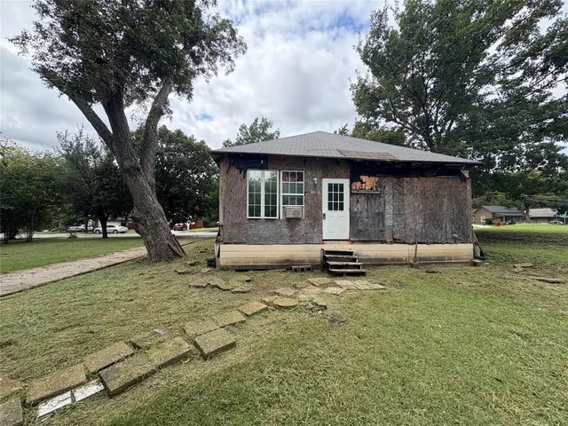 a white house that has a tree in front of it