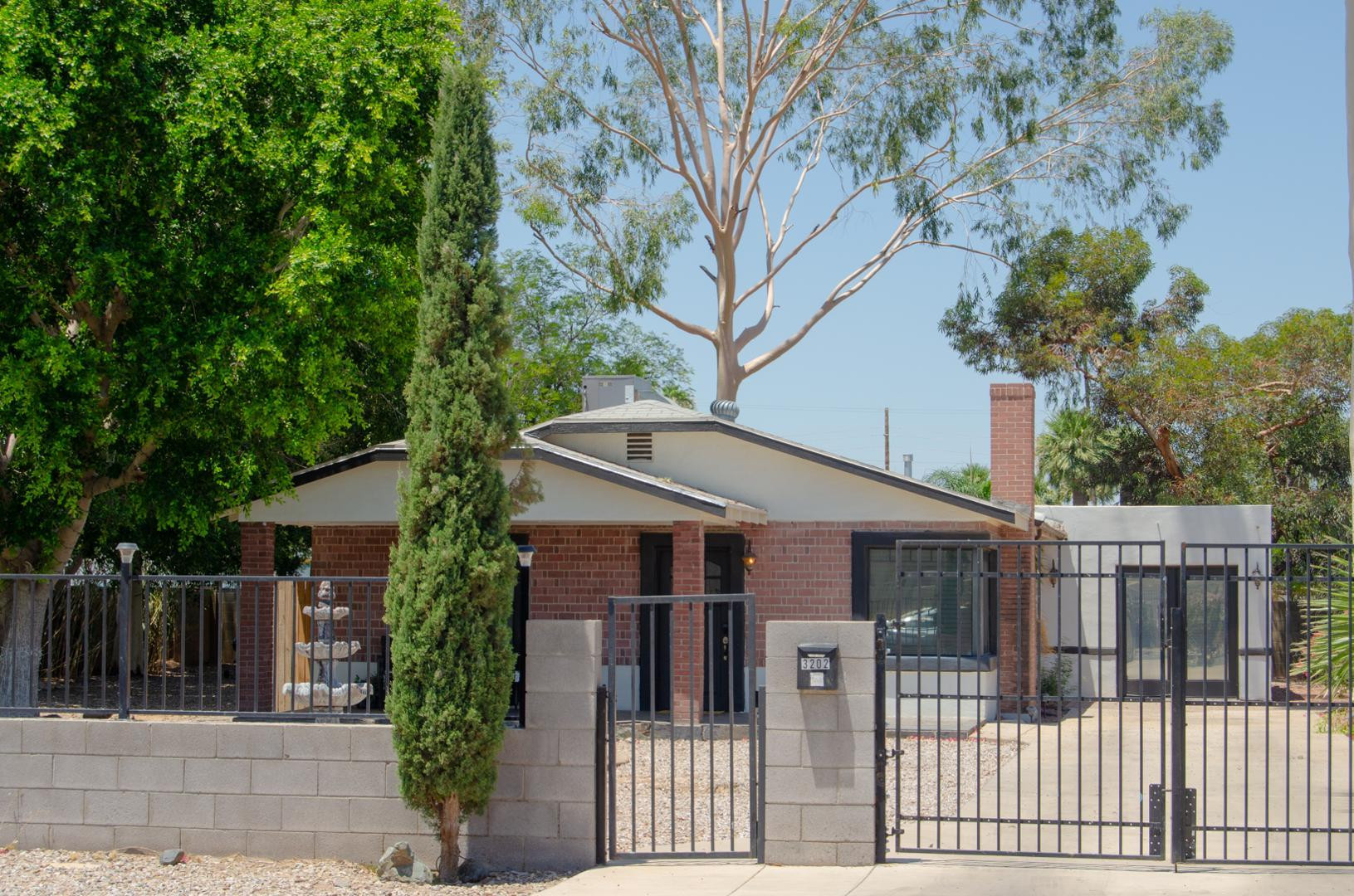 3202 North 37th Street Phoenix, AZ 85018 - Photo 4 of 19 a view of house with wooden fence and trees