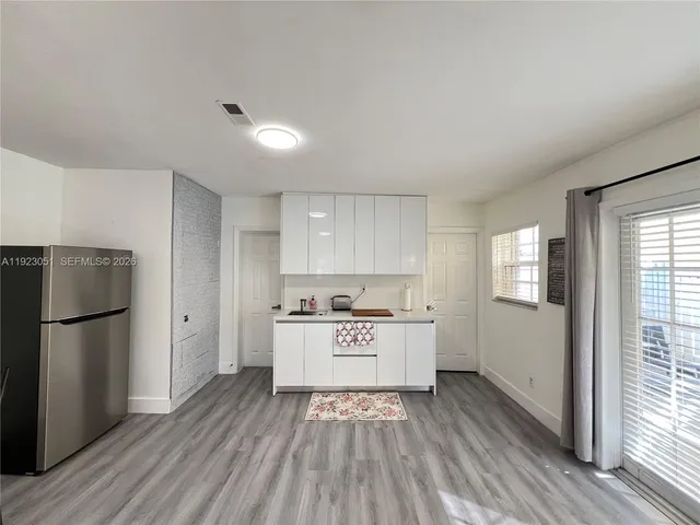 a kitchen with a refrigerator a sink and wooden floor
