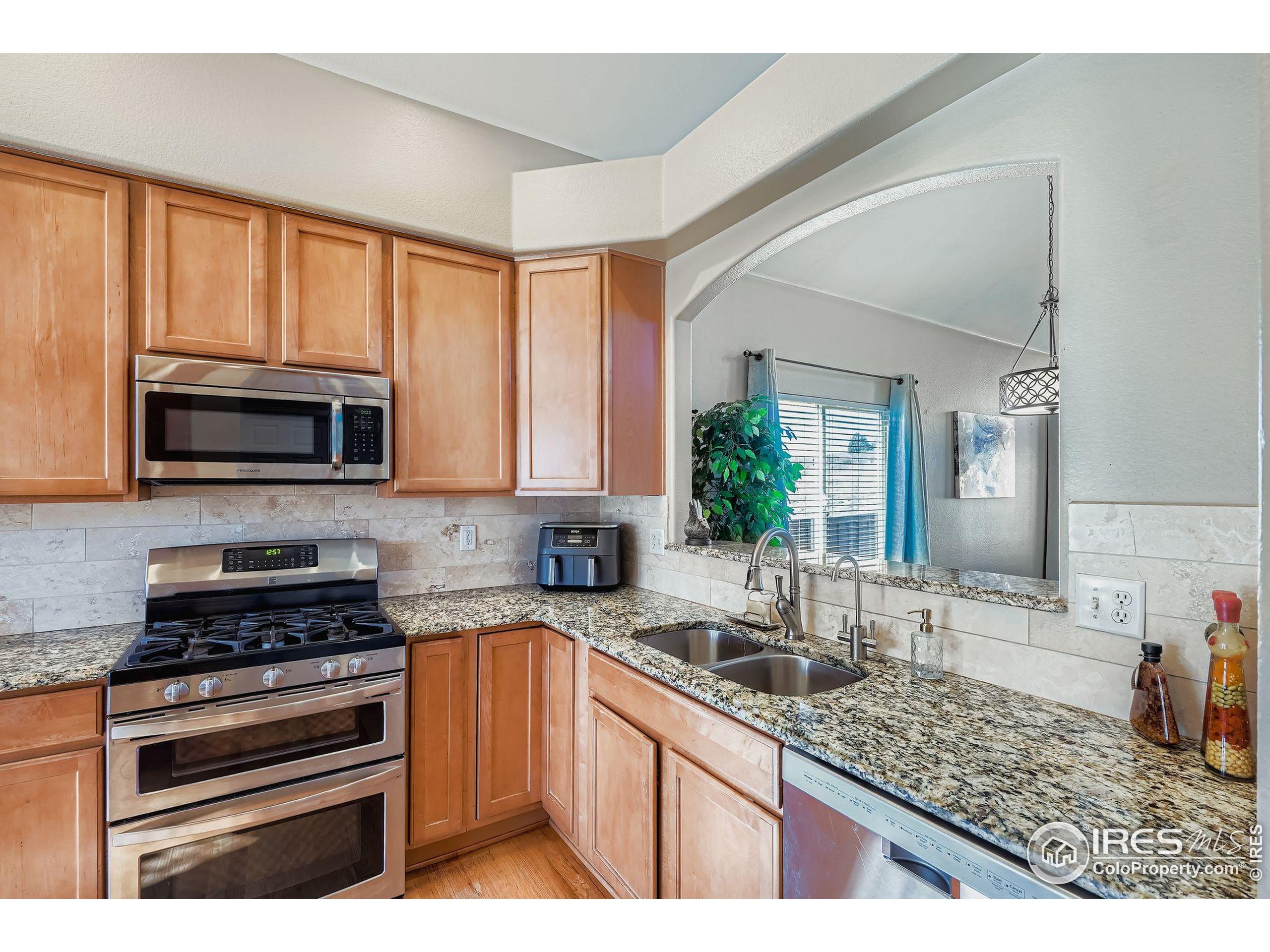 2011 Alpine Drive Erie, CO 80516 - Photo 11 of 21 a kitchen with stainless steel appliances kitchen island granite countertop a sink stove and microwave