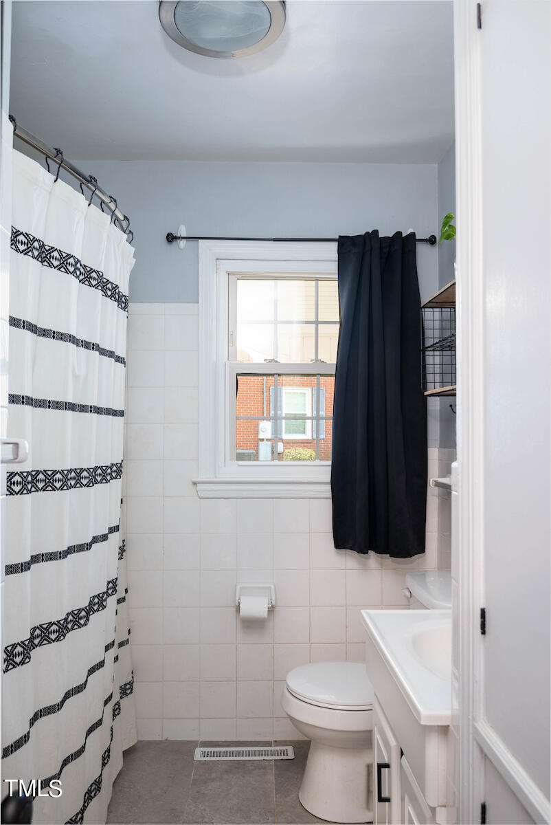 904 Frank Street Roxboro, NC 27573 - Photo 15 of 20 a bathroom with a toilet a sink and a window