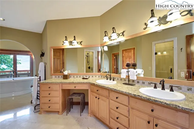 a bathroom with a granite countertop sink a mirror and a bathtub