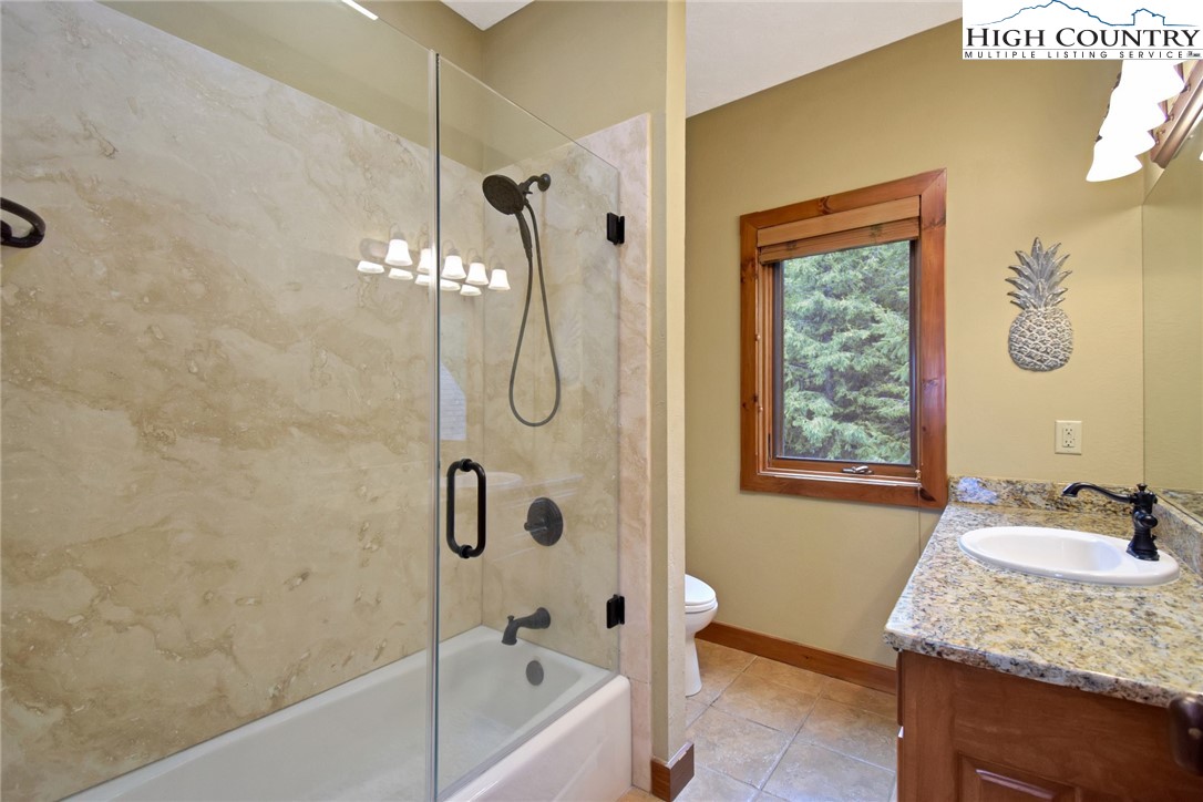 86 Tyneridge Road Banner Elk, NC 28604 - Photo 29 of 50 a bathroom with a granite countertop sink a mirror and a bathtub