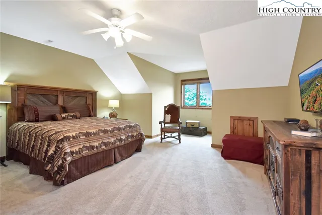 a bedroom with a bed dresser and a chandelier