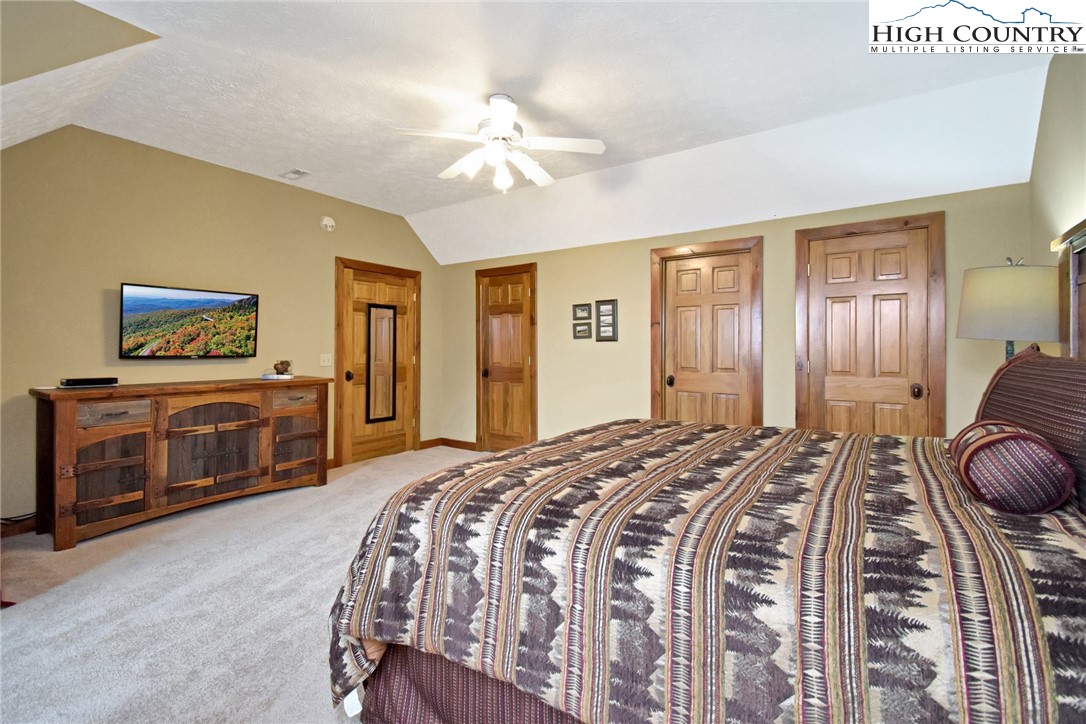 86 Tyneridge Road Banner Elk, NC 28604 - Photo 31 of 50 a spacious bedroom with a bed and a chandelier