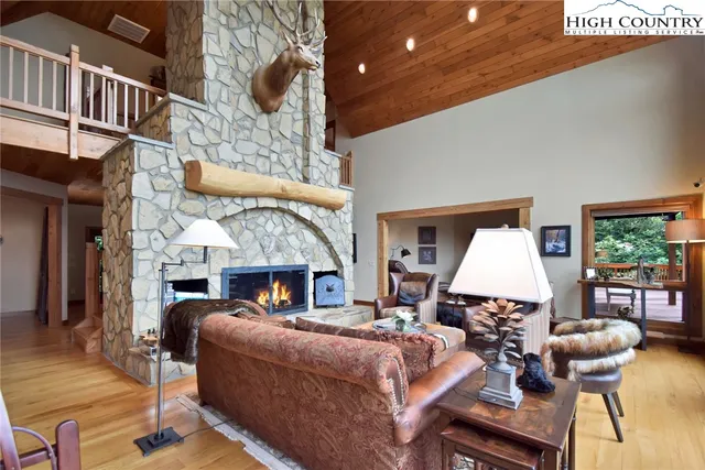a living room with furniture a fireplace and a chandelier