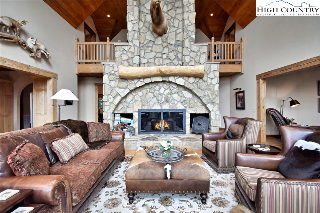 86 Tyneridge Road Banner Elk, NC 28604 - Photo 10 of 50 a living room with furniture a fireplace and a chandelier