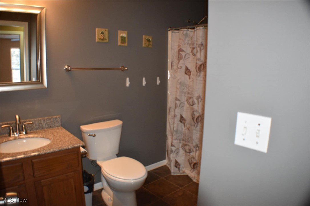 1088 Wadsworth Road Medina, OH 44256 - Photo 17 of 24 Full bathroom featuring tile patterned floors, toilet, curtained shower, and vanity