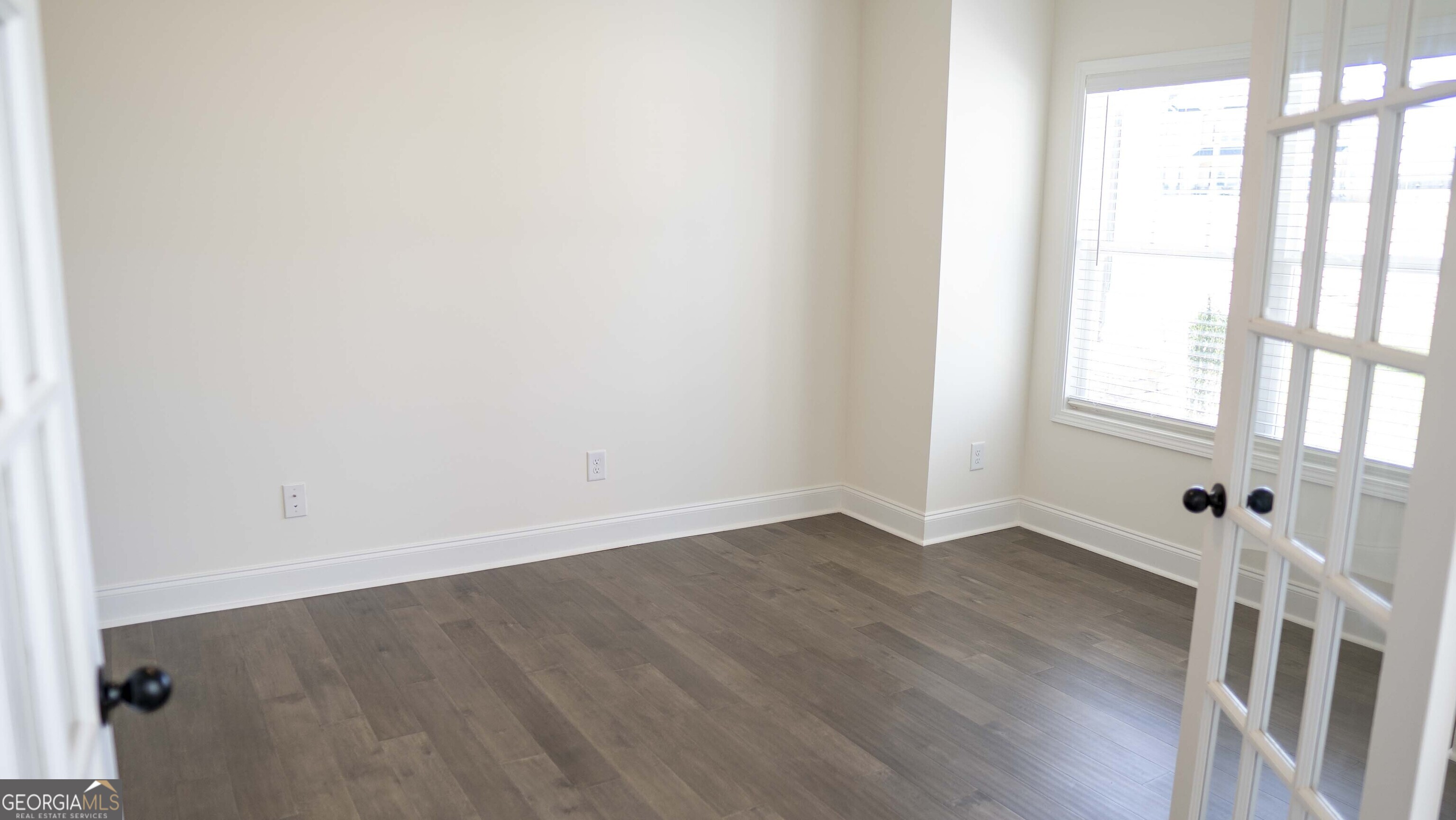 604 Beaver Court Perry, GA 31069 - Photo 6 of 40 an empty room with wooden floor and windows