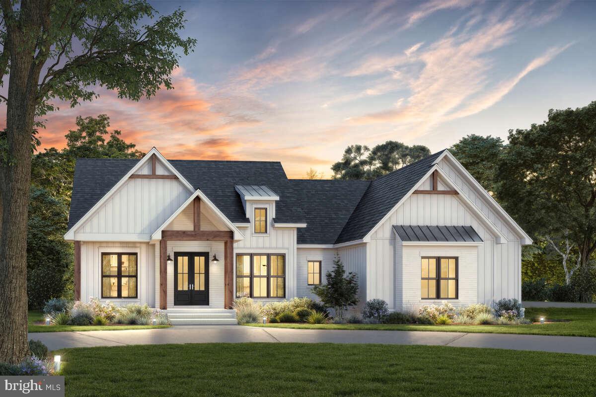a front view of a house with a garden and trees