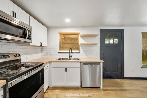 a kitchen with stainless steel appliances a sink stove and cabinets