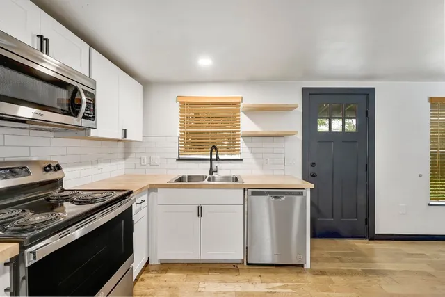a kitchen with stainless steel appliances a sink stove and cabinets