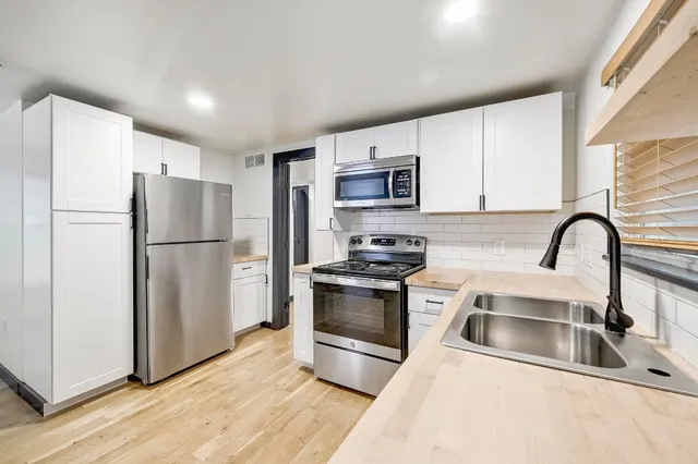 a kitchen with stainless steel appliances a refrigerator sink and microwave