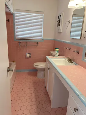 a bathroom with a sink a toilet and a window