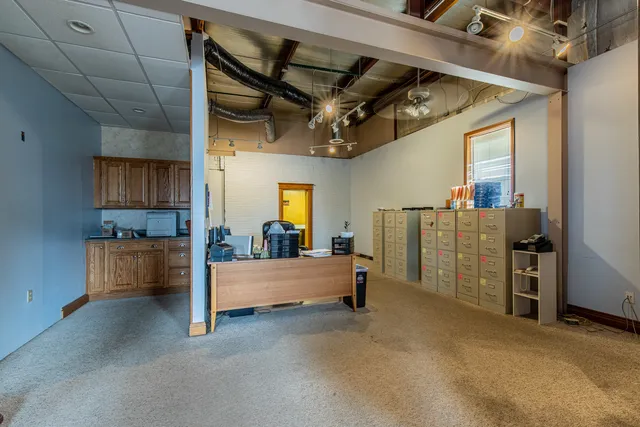 a view of an empty room with wooden floor fireplace and windows