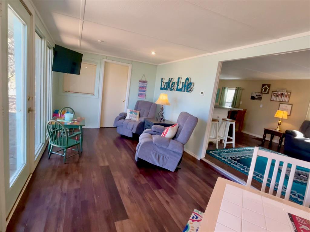 2334 San Bar Road, Unit 50 Graford, TX 76449 - Photo 13 of 40 Sun room with guest bedroom leading into the open concept living-dining area.