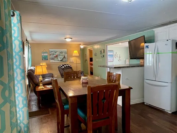 a kitchen with stainless steel appliances a table chairs and a refrigerator