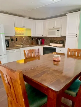 a kitchen with stainless steel appliances granite countertop a sink a stove and white cabinets