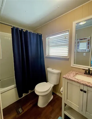 a bathroom with a granite countertop toilet sink and mirror