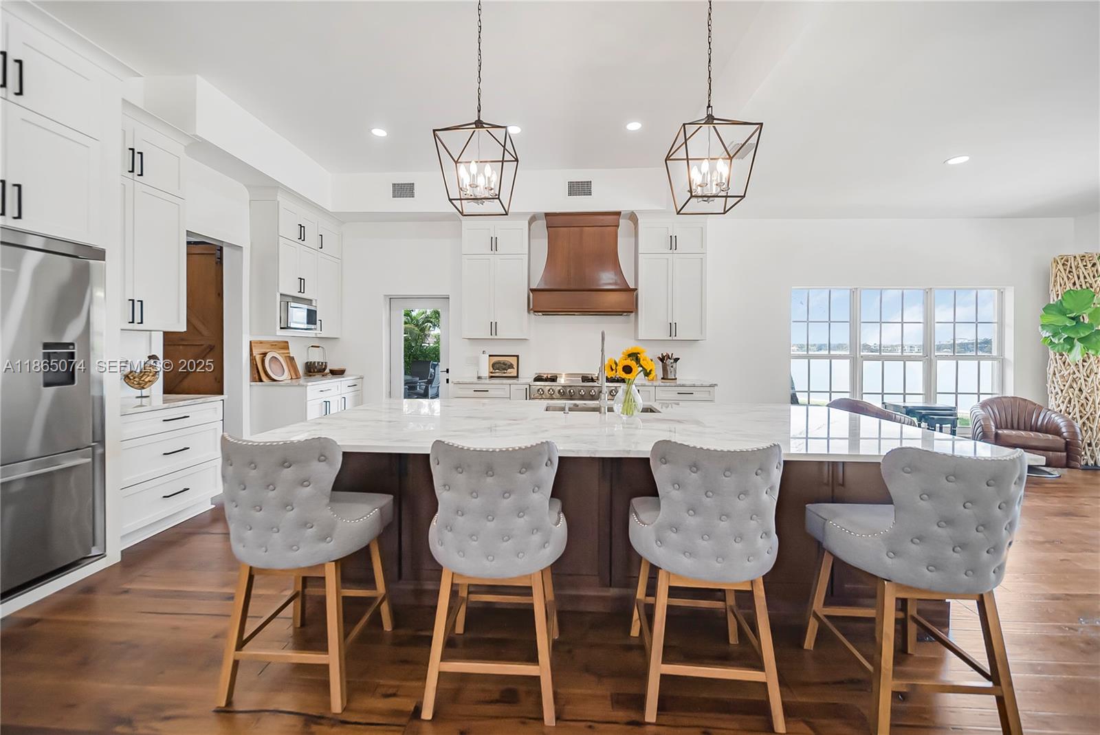1020 Lands End Way Jupiter, FL 33458 - Photo 16 of 79 a view of a dining room with furniture a chandelier and wooden floor