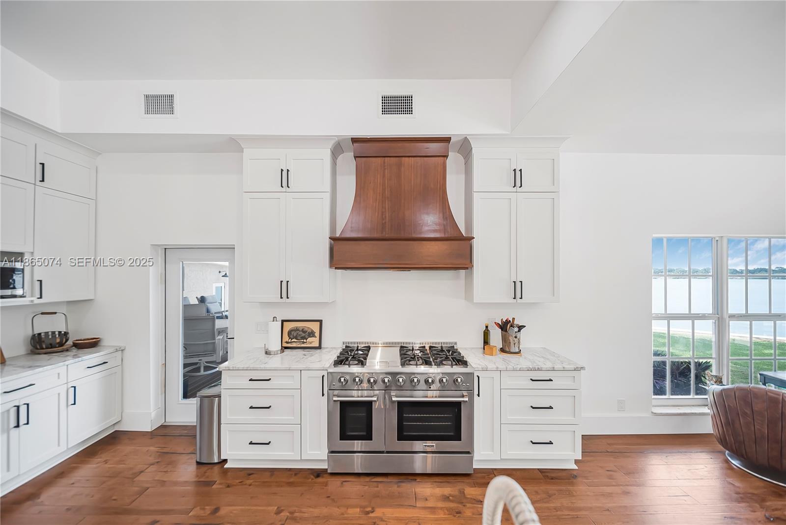 1020 Lands End Way Jupiter, FL 33458 - Photo 20 of 79 a kitchen with cabinets appliances and wooden floor