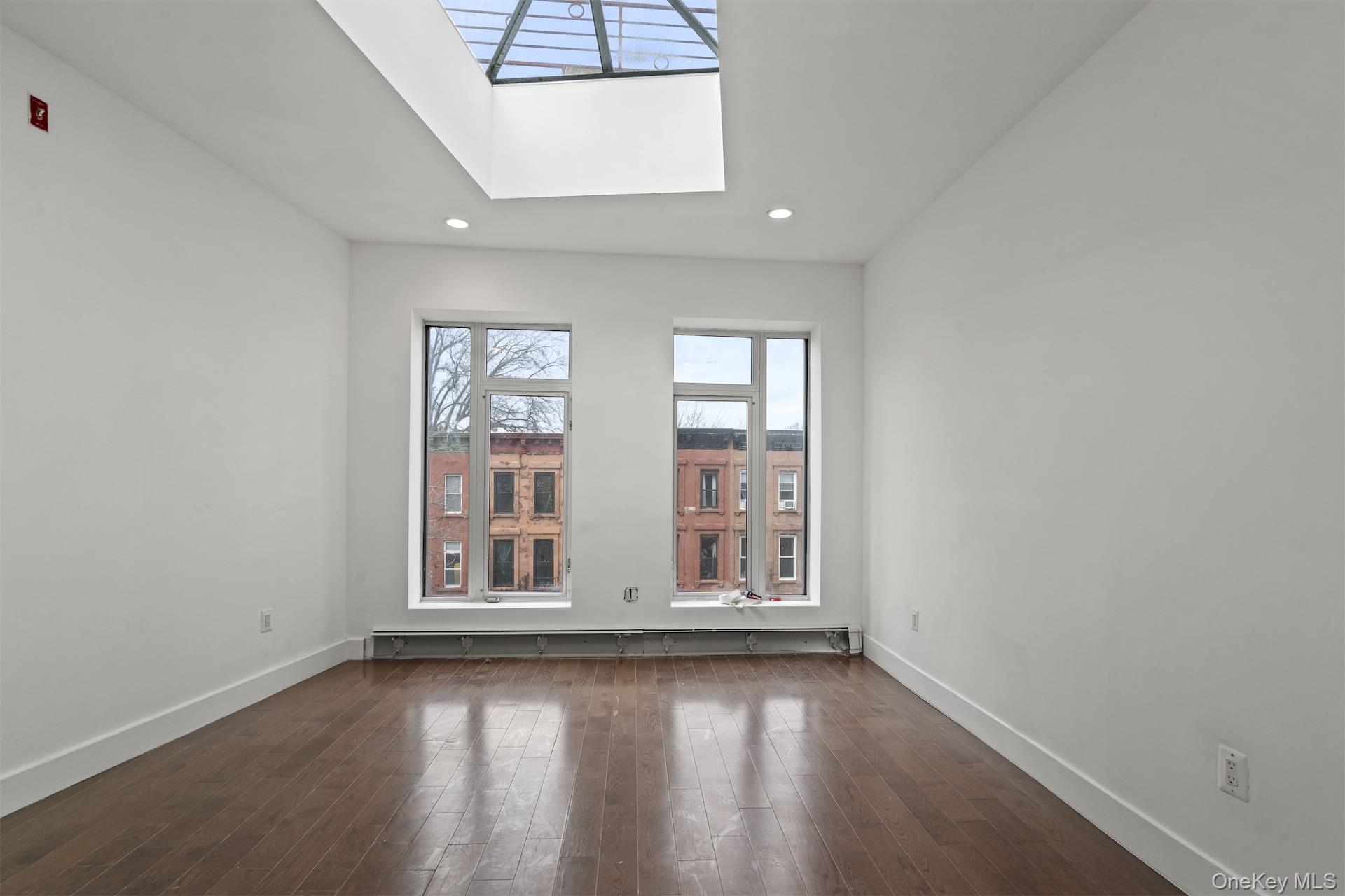 44-46 Decatur Street Brooklyn, NY 11216 - Photo 46 of 50 Empty room with a skylight, dark wood-style floors, and recessed lighting