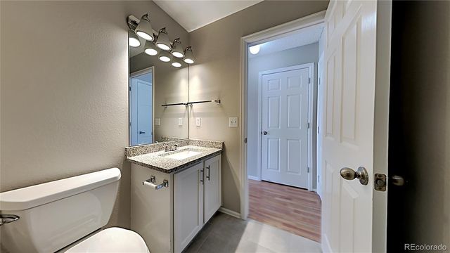 a bathroom with a granite countertop sink a toilet and shower