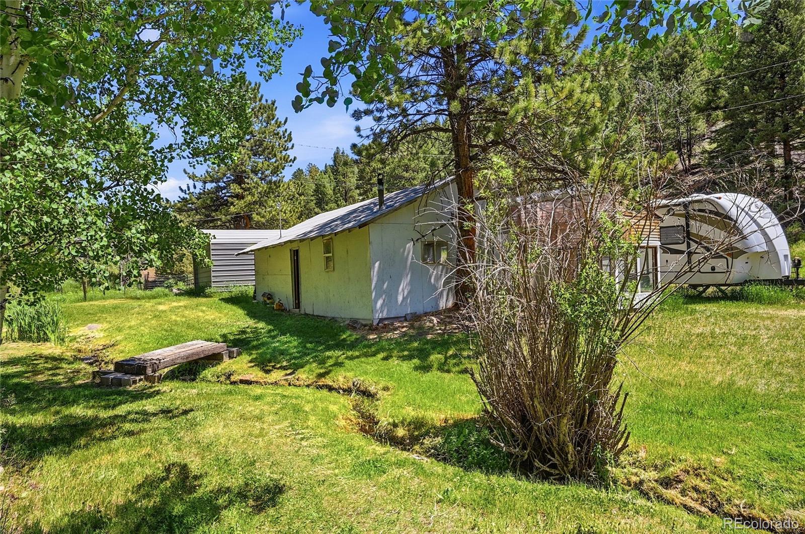 427 Brookside Drive Bailey, CO 80421 - Photo 7 of 37 a backyard of a house with lots of plants and large tree