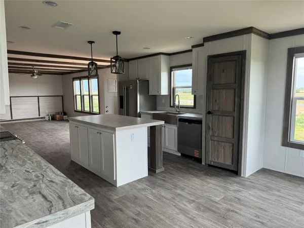 a kitchen with kitchen island a sink a counter space appliances and a window