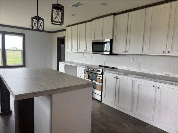 a kitchen with stainless steel appliances granite countertop a sink a stove a microwave and cabinets
