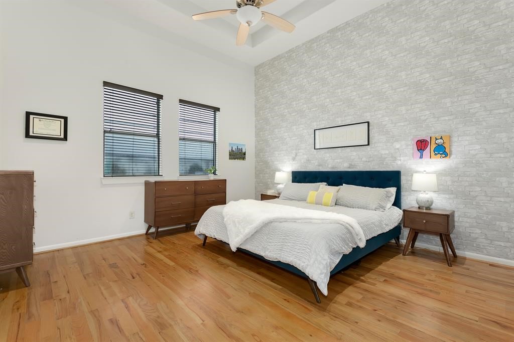 1841 Radcliffe Street Houston, TX 77007 - Photo 16 of 31 a bedroom with a bed and a dresser with wooden floor