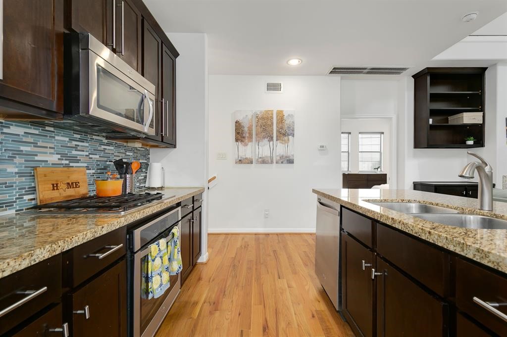 1841 Radcliffe Street Houston, TX 77007 - Photo 7 of 31 a kitchen with stainless steel appliances granite countertop a sink stove microwave and cabinets