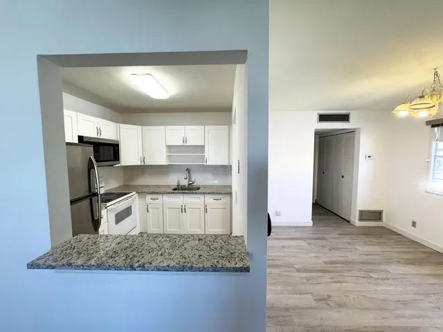 a kitchen with a refrigerator sink and cabinets