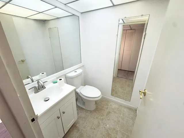 a bathroom with a sink mirror vanity and toilet