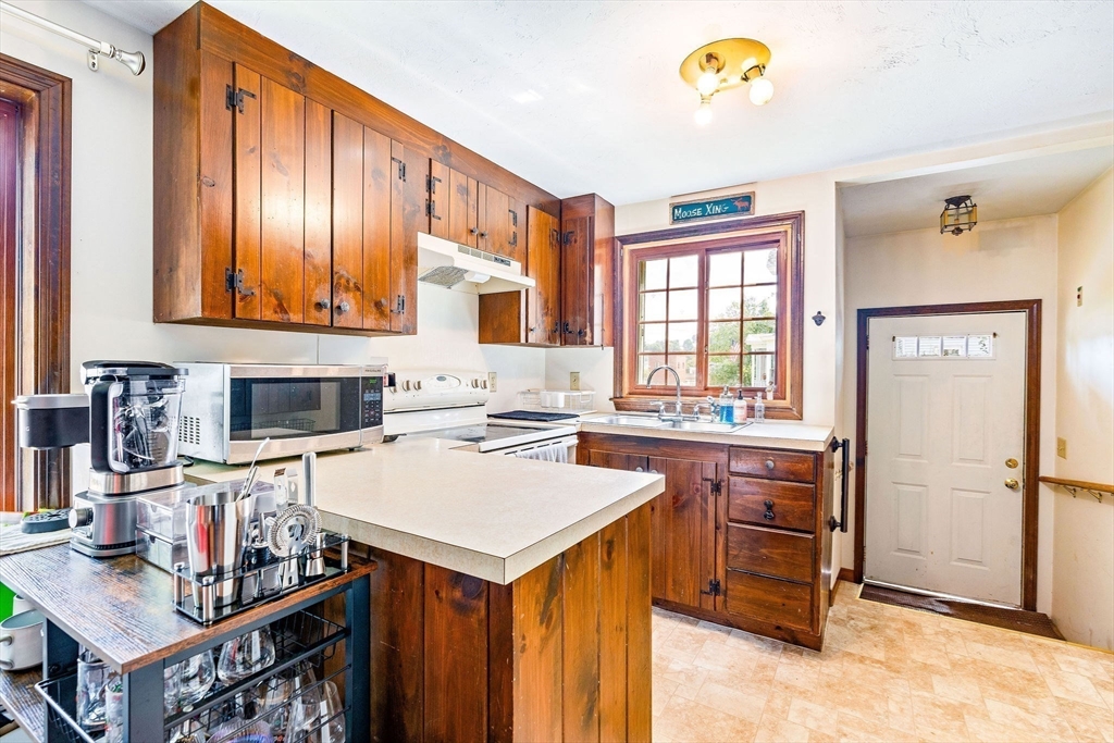30 Pope Street, Unit A Hudson, MA 01749 - Photo 3 of 9 a kitchen with a refrigerator and a stove top oven