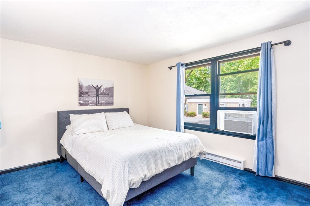 30 Pope Street, Unit A Hudson, MA 01749 - Photo 5 of 9 a bedroom with a large bed and a large window