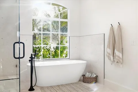 a white bath tub sitting next to a shower