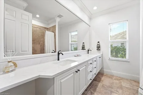 a bathroom with double vanity sinks a large mirror and a shower