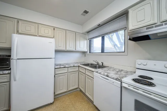 a kitchen with a stove a refrigerator and a sink