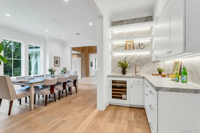 a kitchen with white cabinets and window
