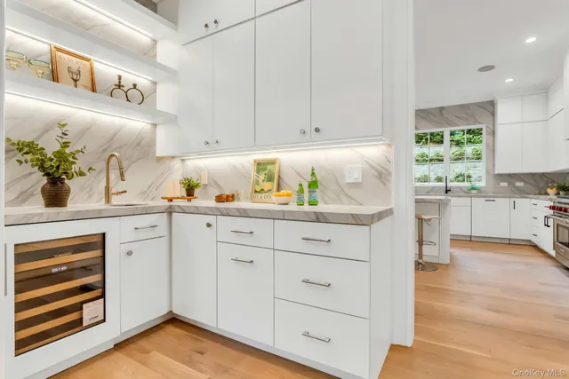 a living room filled with white furniture and wooden floor
