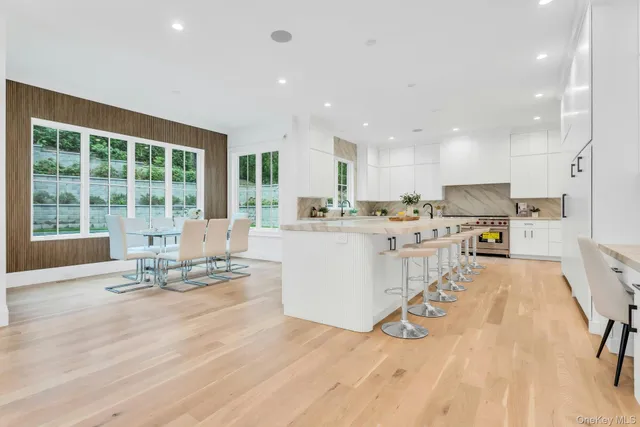a large white kitchen with kitchen island a sink a stove and a refrigerator