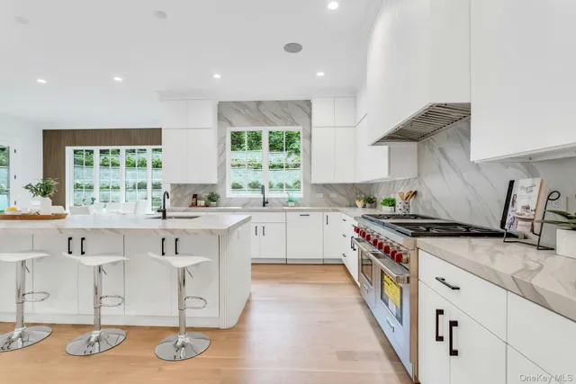 a kitchen with white cabinets and chairs