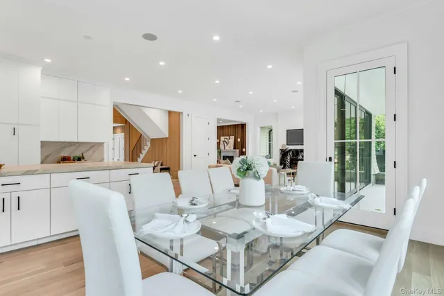 a kitchen with stainless steel appliances granite countertop a kitchen island a stove a table and a refrigerator