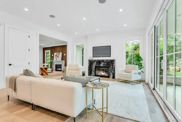 a living room with furniture a fireplace and a floor to ceiling window